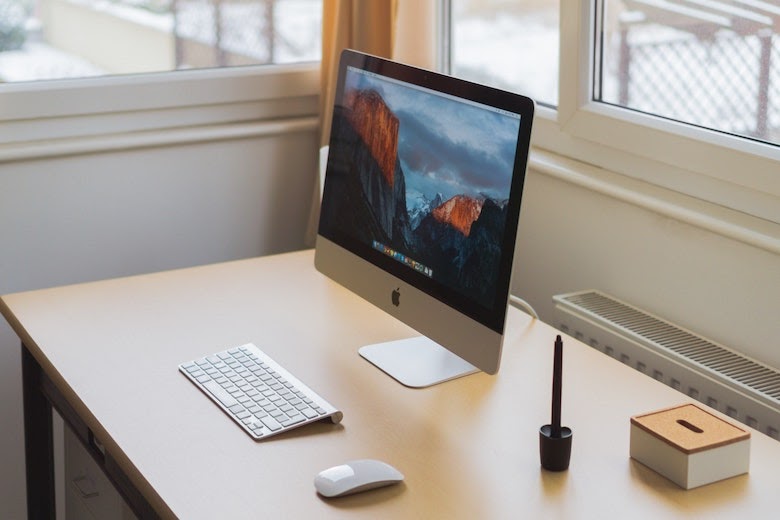 iMac computer on wooden desk | remote access management for IT services contractors