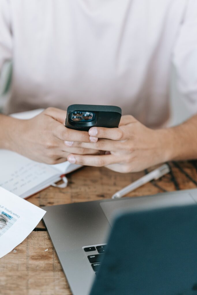 Hands using smartphone at a desk