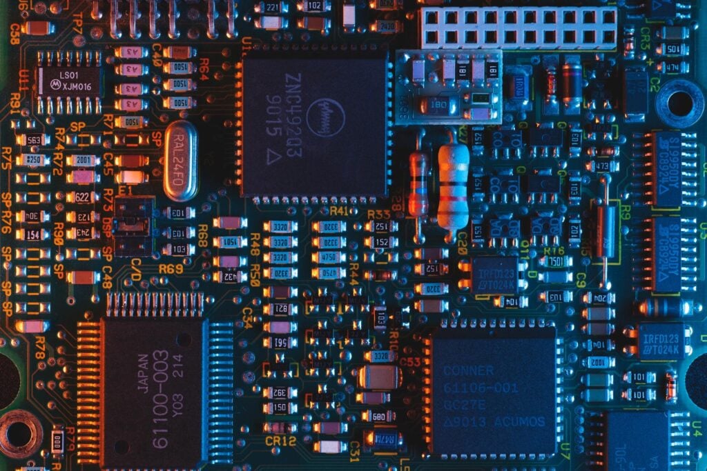 Close-up of a computer circuit board illuminated by red and blue light.