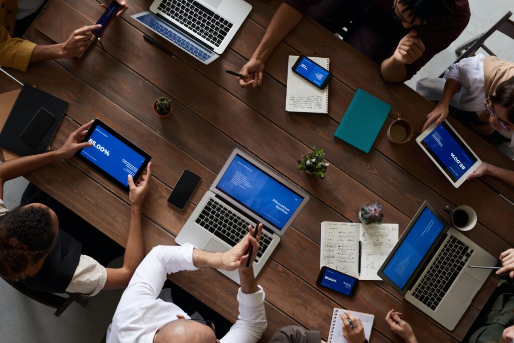 office workers sitting around a table with mobile devices