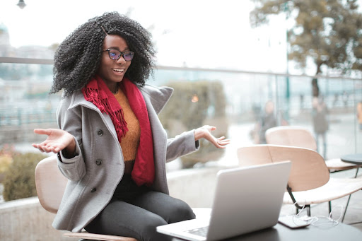 woman shrugging at her laptop