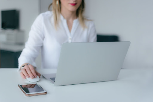 woman behind a laptop toggling on the mouse