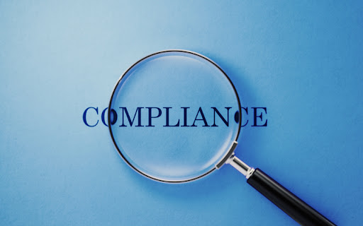Magnifier and compliance text on blue background. Horizontal composition with copy space.