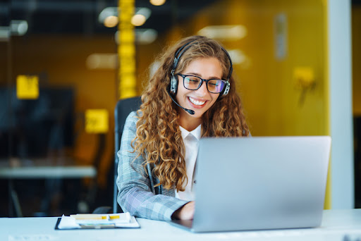 Call center agent with headset working on support hotline in modern office. Video conference.  Оnline training.