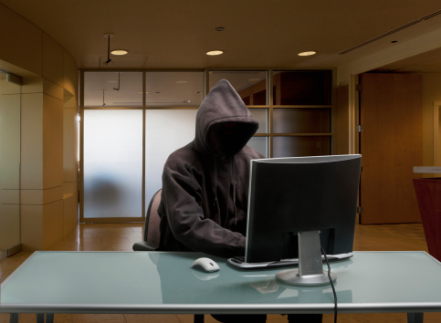 Caucasian man in hoody sitting at office desk