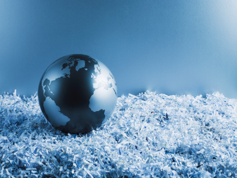 Metal globe on shredded paper