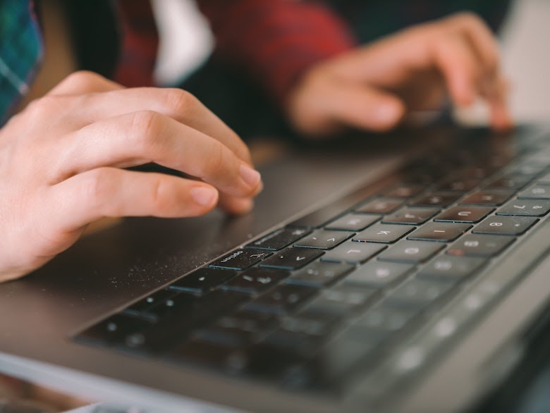 person typing on laptop mousepad